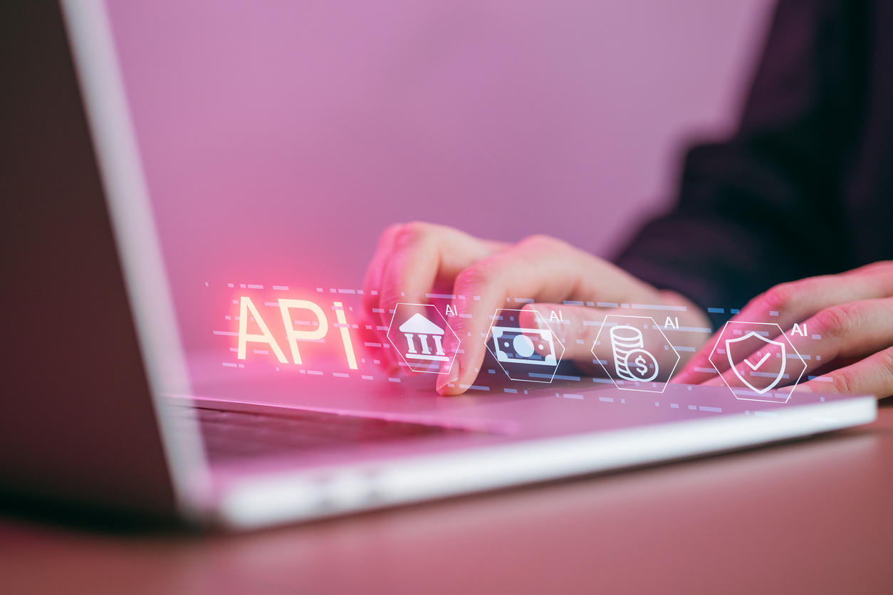 Interoperabilità nella PA: mani al computer con grafica digitale che richiama API, dati, sicurezza e servizi pubblici digitali.